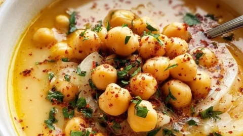Bowl of delicious Garlic Chickpea Soup garnished with herbs