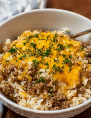 Cheesy Ground Beef and Rice Casserole topped with melted cheese and herbs