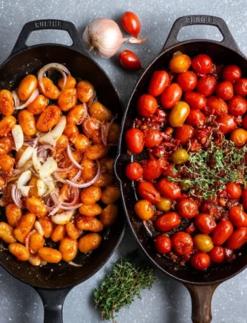 Creamy roasted tomato gnocchi dish served in a bowl with fresh basil