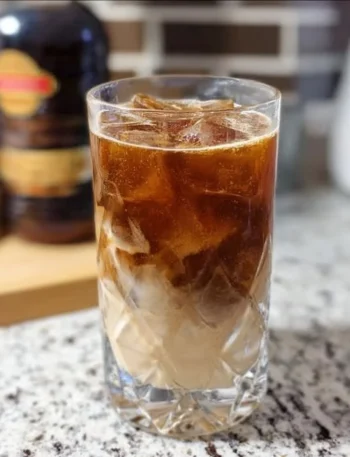 Creamy Root Beer Rum Cocktail served in a glass with ice and a straw