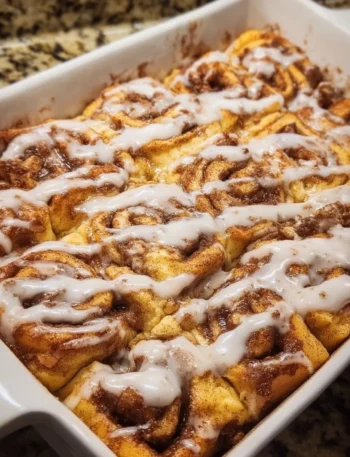 Easy cinnamon roll casserole baked dish topped with icing and cinnamon