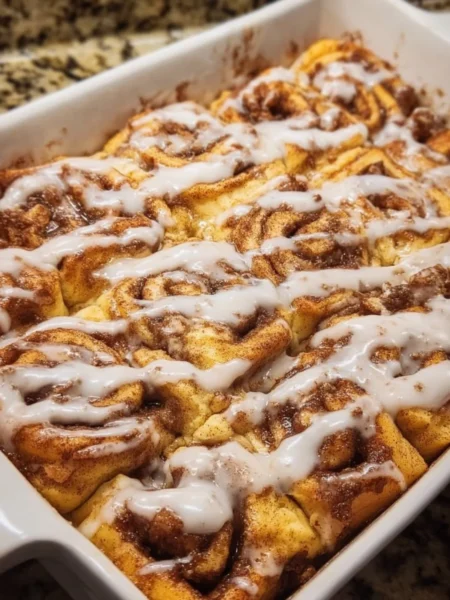 Easy cinnamon roll casserole baked dish topped with icing and cinnamon
