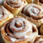 Freshly baked homemade cinnamon rolls topped with creamy icing