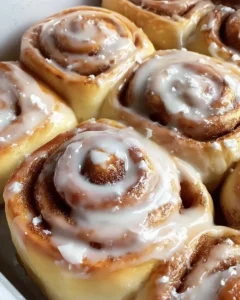 Freshly baked homemade cinnamon rolls topped with creamy icing