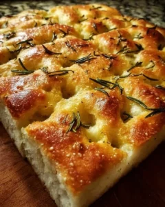 A freshly baked homemade focaccia bread topped with herbs and olive oil