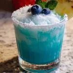 Jack Frost Cocktail garnished with mint and blueberries in a glass, ideal for winter parties.