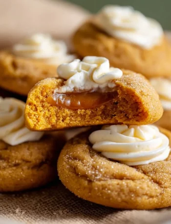 Freshly baked Pumpkin Pie Cookies on a wooden table with autumn leaves