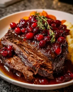 Slow-Braised Beef Roast with Cranberry Balsamic Glaze plated with herbs