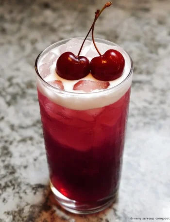Refreshing Tropical Cherry Rum Cocktail garnished with cherries and tropical fruits.