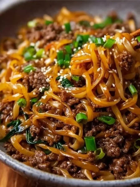 Bowl of easy Mongolian Ground Beef Noodles garnished with green onions