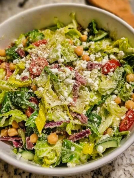 A vibrant bowl of Scala Chopped Salad with fresh vegetables and dressings